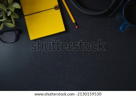 top view working desk notebook,headphone and coffee cup on black table background