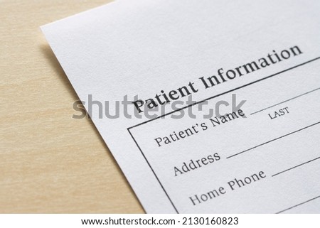 Closeup of a blank patient information form isolated on a wooden background. Royalty-Free Stock Photo #2130160823