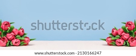 bunch of pink tulips on a white wooden table on blue Royalty-Free Stock Photo #2130166247