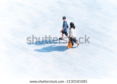 Human life in Social distance. Top view couple people with face mask walk on the pedestrian street walkway. (Aerial urban city photo)