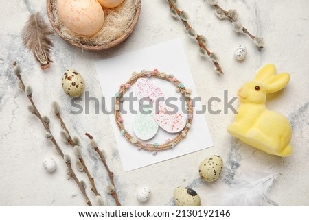 Beautiful Easter composition with greeting card, eggs, bunny and pussy willow branches on light background