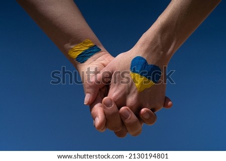 female hands painted in Ukraine flag colors yellow-blue holding. Stop the war and the power of Ukraine, patriotism and Kiev, strength and power Royalty-Free Stock Photo #2130194801