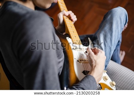 A man playing electric guitar on a bed Royalty-Free Stock Photo #2130203258