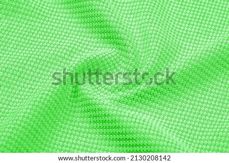 Green silk fabric. Grunge surface texture with fine grains, green satin texture, which is an emerald fabric, silk panorama, with a beautiful soft natural blur pattern.
