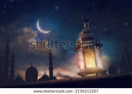 Ornamental Arabic lantern with burning candle glowing at night. Festive greeting card, invitation for Muslim holy month Ramadan Kareem. Royalty-Free Stock Photo #2130212207