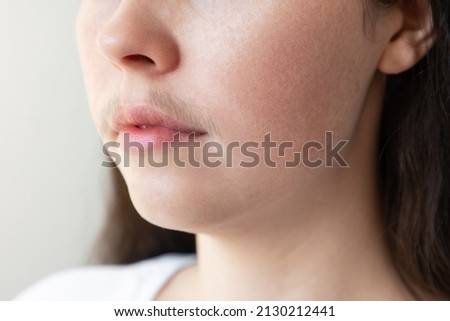 A close-up of a woman's face with a mustache over her upper lip. The concept of hair removal and epilation. Royalty-Free Stock Photo #2130212441