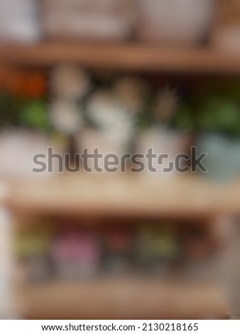 Defocused abstract background of flower on the plastic pots placed in the wooden shelf