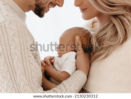 New parents smiling and holding their newborn baby girl. Royalty-Free Stock Photo #2130230312
