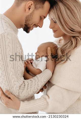 New parents smiling and holding their newborn baby girl.  Royalty-Free Stock Photo #2130230324