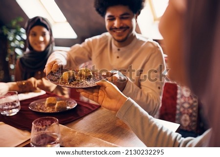 Close-up of Muslim people eating baklava for dessert at home. Royalty-Free Stock Photo #2130232295