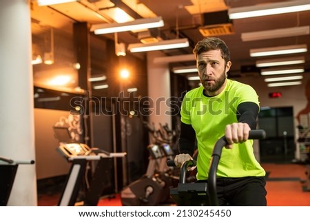 Dedicated sportsman exercising in gym. Fit male athlete is doing cardiovascular exercise. He is wearing sportswear. Royalty-Free Stock Photo #2130245450