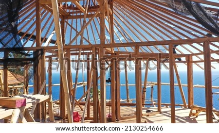 Inside a timber house under construction. Detailed photo of a wooden roof overlap construction.