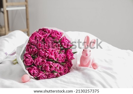 Bouquet of flowers, Easter bunny and eggs on soft bed