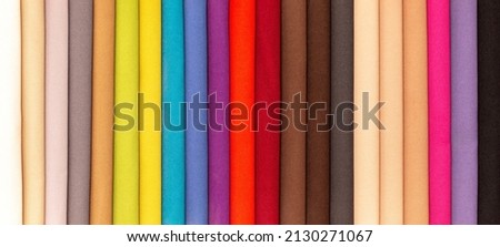 Fabric texture close up. Fabric swatches in different colors are stacked for selection. A variety of shades of upholstery material for furniture and interior. A set of multi-colored rolls of material. Royalty-Free Stock Photo #2130271067