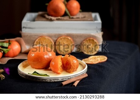 Organic  tangerine jam with cinnamon sticks on a dark background, close up, still life photography