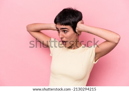Young caucasian woman isolated on pink background screaming, very excited, passionate, satisfied with something.