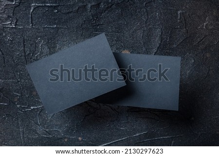 Black business card mockup, front and back, on a dark background, a template for design presentation, thick cardboard visiting cards floating on black