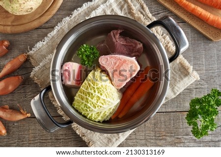 Ingredients for broth or soup in a pot - bones, beef meat and vegetables, top view
