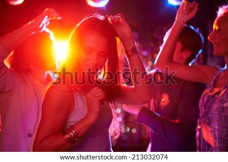 Pretty girls dancing in night club on background of guys Royalty-Free Stock Photo #213032074