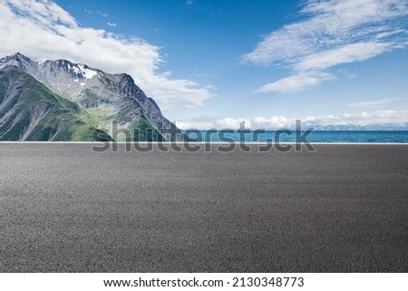 Asphalt road and mountain with lake natural scenery under blue sky