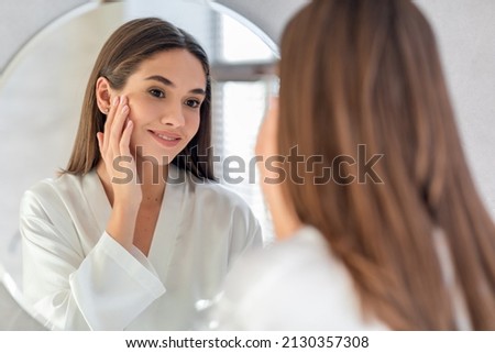 Natural Beauty. Portrait Of Attractive Young Female Smiling To Her Reflection In Mirror, Beautiful Millennial Woman Enjoying Her Appearance While Getting Ready In Bathroom, Selective Focus Royalty-Free Stock Photo #2130357308