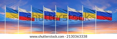 The flags of Ukraine and Russia are waving in the sky. The concept of tense relations between Ukraine and Russia