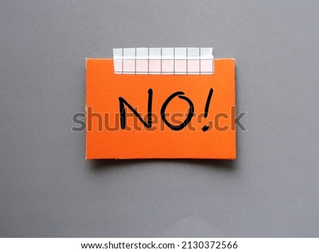 Orange card paper on gray background with handwritten text NO , concept of learning to say no without feeling guilty , stop people pleasing, create personal boundaries based on what you really want Royalty-Free Stock Photo #2130372566