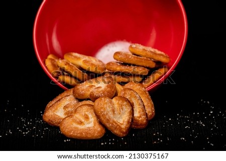 Hearts Shaped Biscuit In Red Round Bowl, Biscuits Heap, Isolated on Black Background