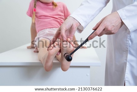 A doctor, a neurologist, checks the babinsky reflex on the sole of the foot. Neurological hammer. Children's neuralgia Royalty-Free Stock Photo #2130376622