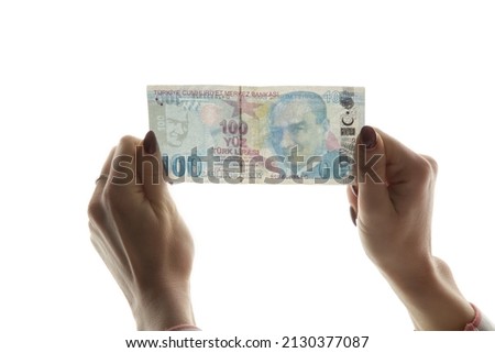  Woman checking Turkish lira banknote against light. Fake money concept.