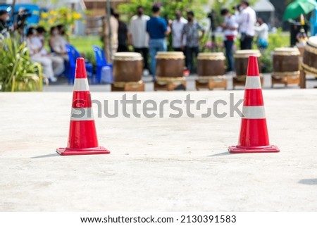 traffic sign. Orange cone with white stripes at road background. Parking lot with traffic cone on street used warning sign on road.