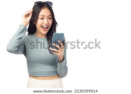 Happy and excited young woman using mobile phone standing over isolated on white background and copy space Young girl using smartphone for shopping online chat and texting message She get surprised Royalty-Free Stock Photo #2130399014