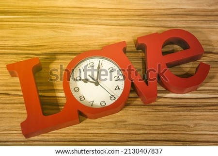 love wooden letters on clock in red color
