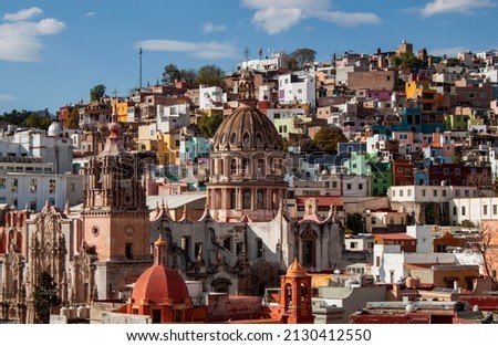 Dome of La Valenciana or San Cayetano church and colorful historical old town buildings in Guanajuato state, Mexico. Vivid, multicolored colonial neighborhood with traditional Mexican architecture. 