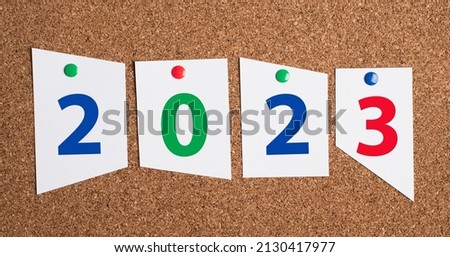 The new year 2023 is standing on paper pinned to a corkboard
