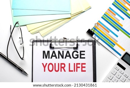 MANAGE YOUR LIFE text on the paper sheet with chart,color paper and calculator