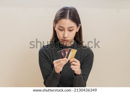 Financial owe, hand of asian woman, girl hand in holding, looking at many credit card, stressed  by calculate expense from bill, no money to pay, mortgage or loan. Debt, bankruptcy or bankrupt.