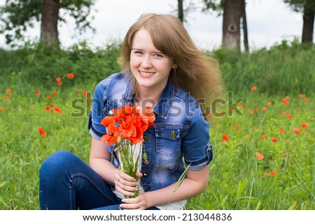 young girl in a field with red flowers