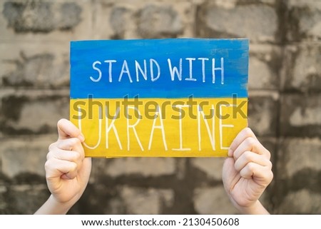 Demonstrator holding "Stand with Ukraine" placard Royalty-Free Stock Photo #2130450608