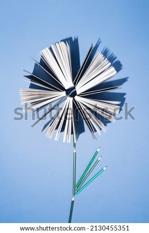 Old books and pencils on bright blue background. Education, knowledge or Nature concept. Flat lay.