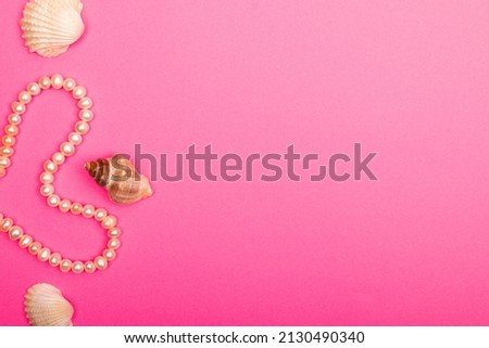 Feminine desktop mockup with pearls  on pink background with copy space.