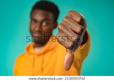 Dissatisfied african american man show thumb down sign in studio