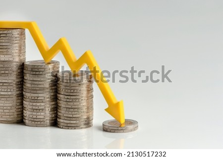 Inflation. The recession of the economy and the euro. The concept of economic collapse and the collapse of the stock exchange in the euro zone. Stacks of coins and a graph arrow pointing down. Royalty-Free Stock Photo #2130517232
