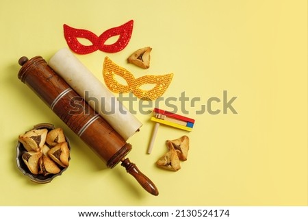 Purim Festival objects and Scroll of Esther on Yellow background Royalty-Free Stock Photo #2130524174
