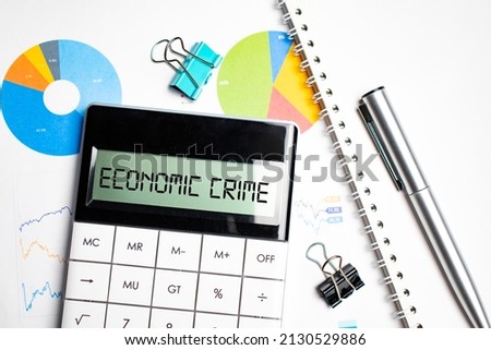 Calculator with text on the display Economic Crime it is on the financial charts with eyeglasses, can be use as financial and business concept