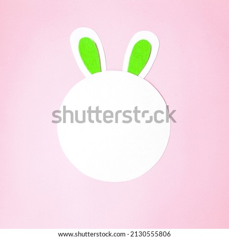 Flat lay, on a soft pink background, bunny ears next to copy space for text.  Holiday concept light happy easter, children's creativity.  Close-up.  Top view, foreground.