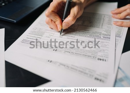 Woman filling US tax form 1040. tax form us business income office hand fill concept. Closeup Royalty-Free Stock Photo #2130562466