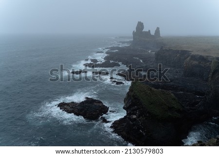 Western Iceland nature landscape. Basalt rock cliff Londrangar in Snaefellsnes (Snæfellsnes) peninsula. Stormy waves at rainy weather
