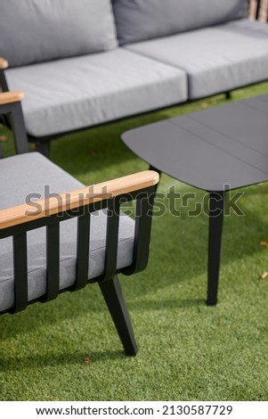 black sofa in the courtyard of the home garden on the grass, close-up