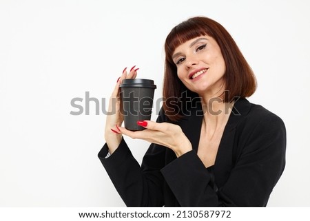 photo pretty woman in a black suit a mug with a drink charm isolated background